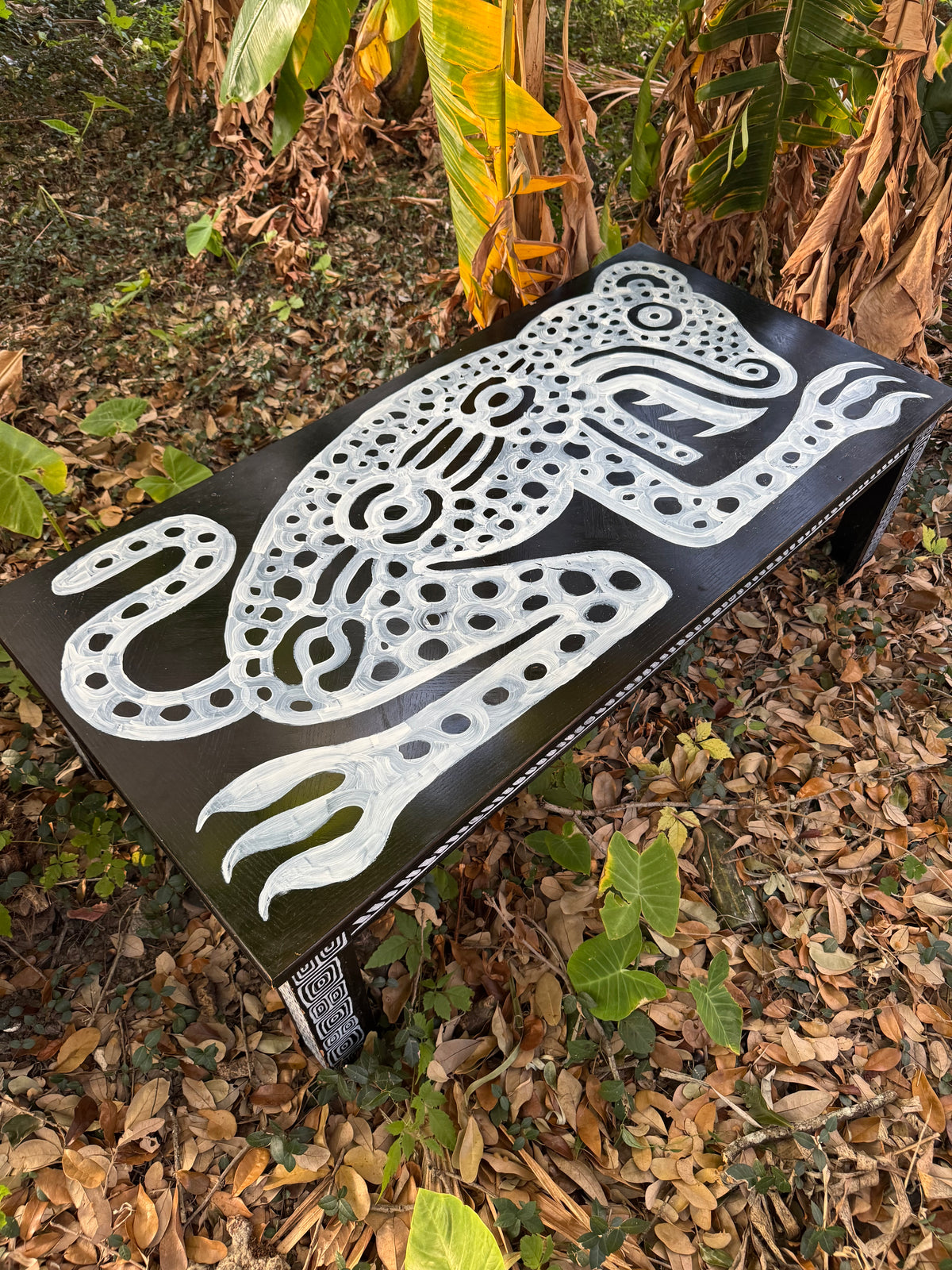 White ornamental painted design on a black triangular object outdoors