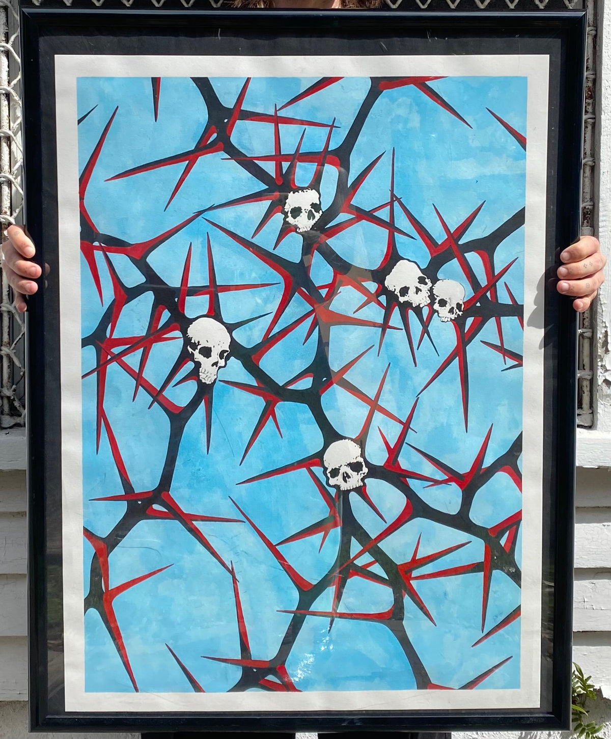 Framed skulls and red branching shapes against a blue background