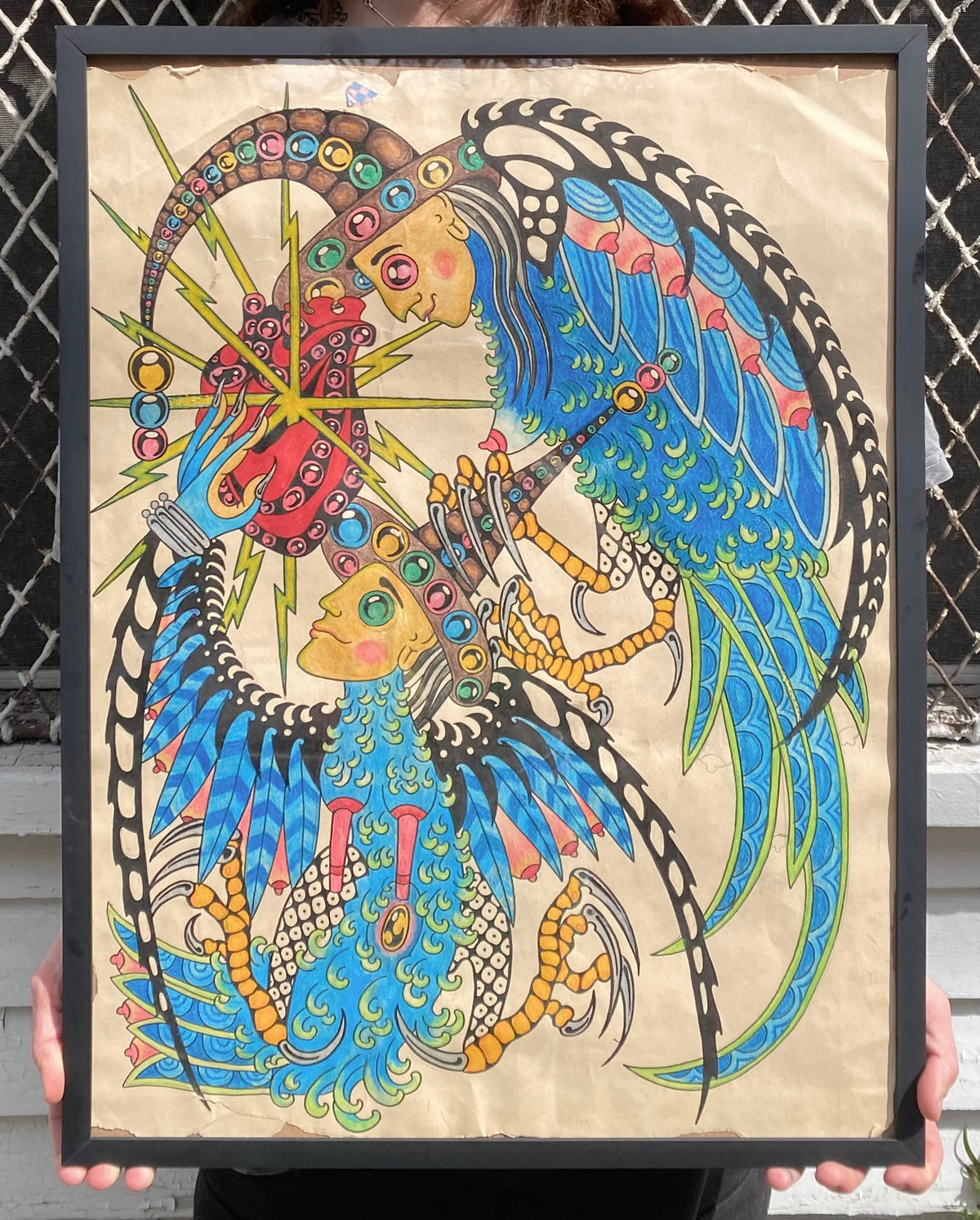 Colorful winged figure with circular motifs in a framed original artwork