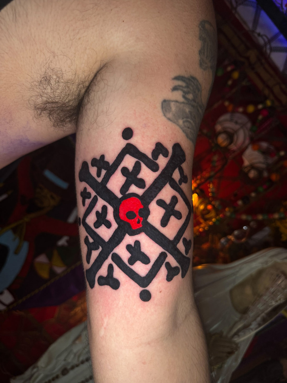 Black and red geometric tattoo on the upper arm