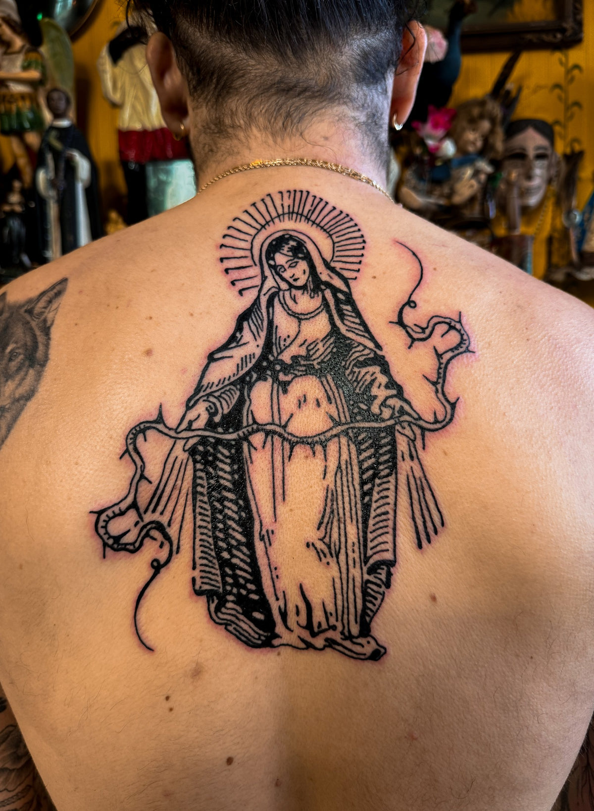 Figure with halo tattoo on the upper back