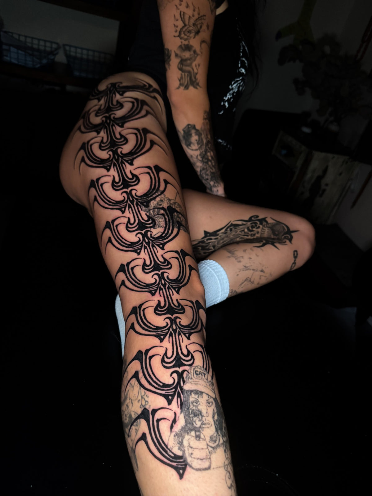 Flowing black ornamental leg tattoo