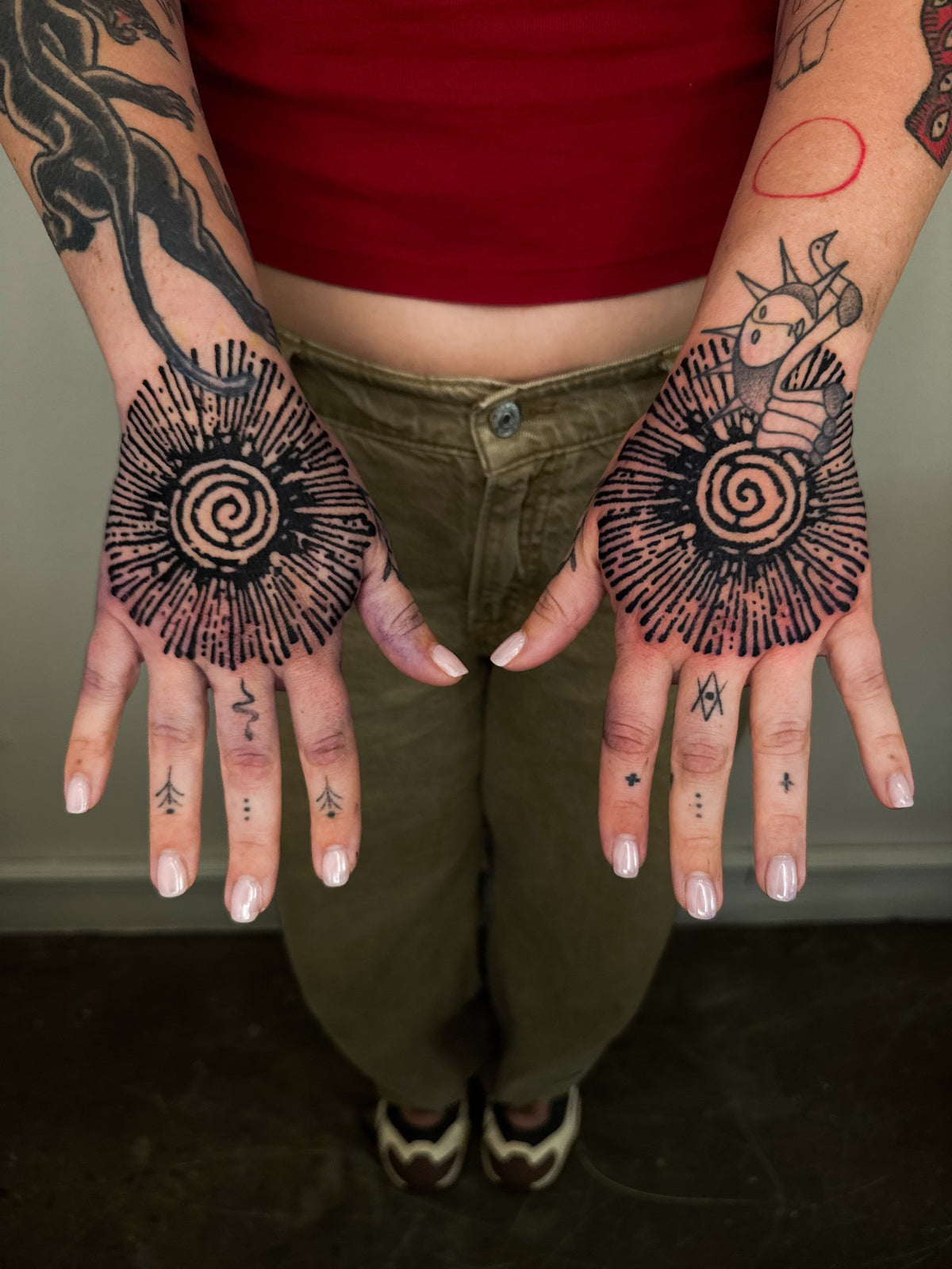 Matching sunburst tattoos on both hands